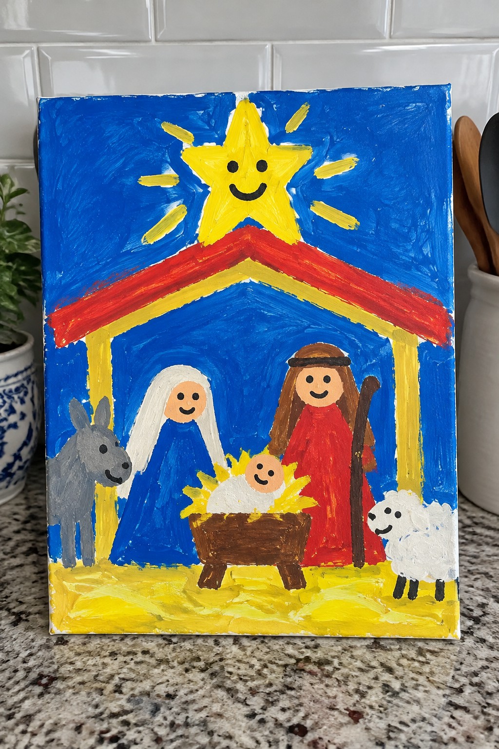 Child's vibrant painting of nativity with smiling star, Mary, Joseph, manger, donkey and sheep.