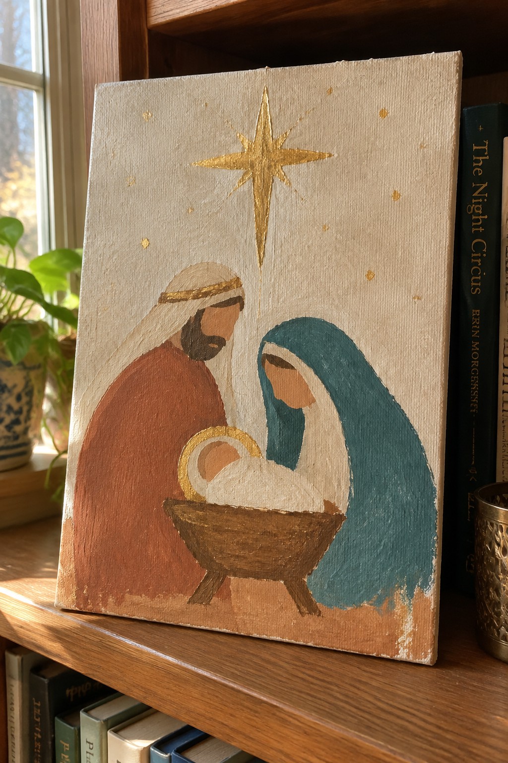 Painted nativity scene with Mary in teal veil, Joseph in brown robe, golden star above manger.