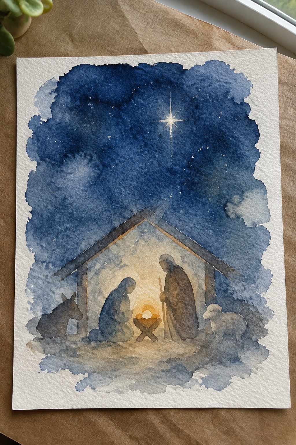 Watercolor nativity with Mary, Joseph, manger, donkey and sheep beneath starry night sky