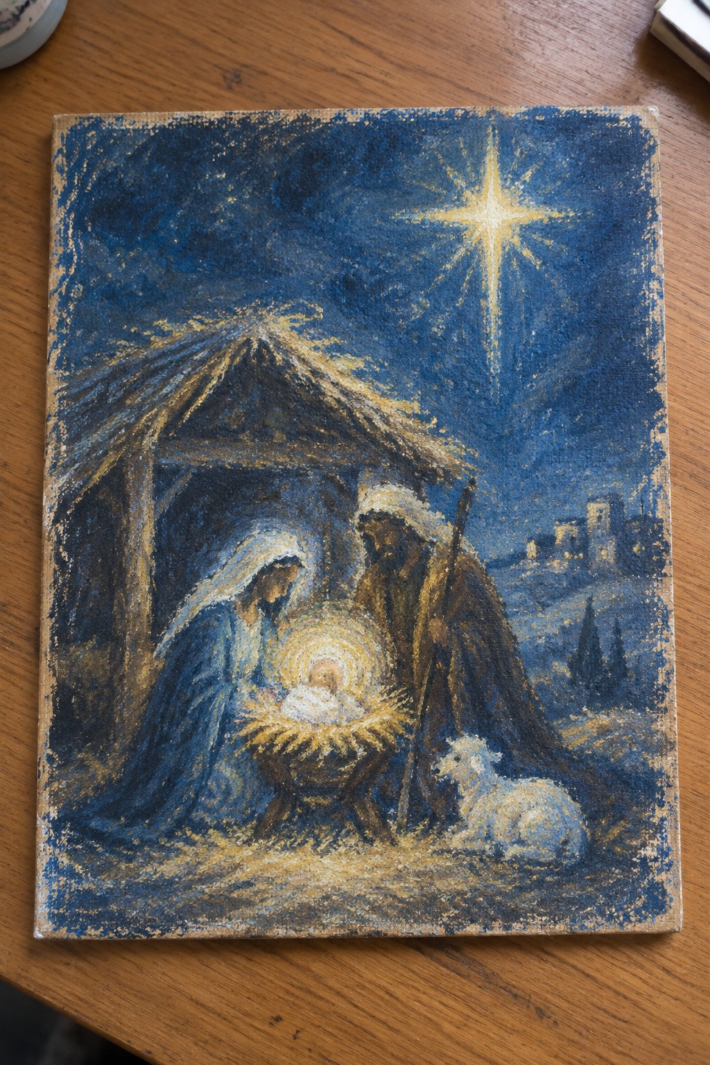 Nativity painting: Mary in blue veil kneels by glowing manger with Joseph, lamb, bright star.