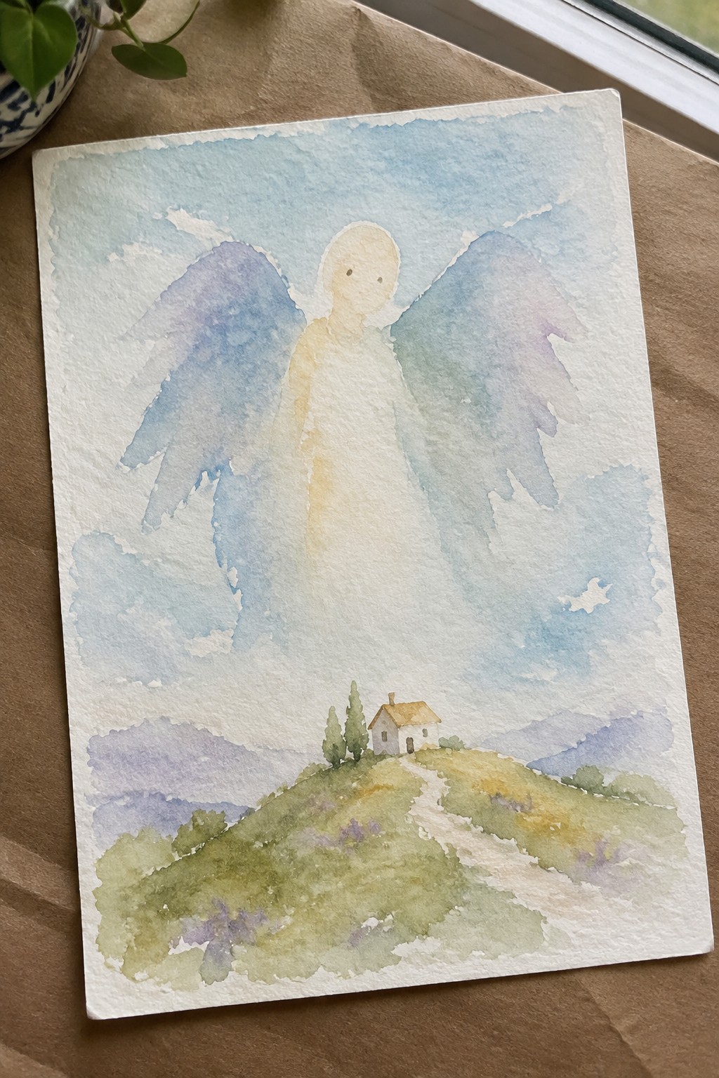 Watercolor of a glowing angel with blue-purple wings above a house on a green hill