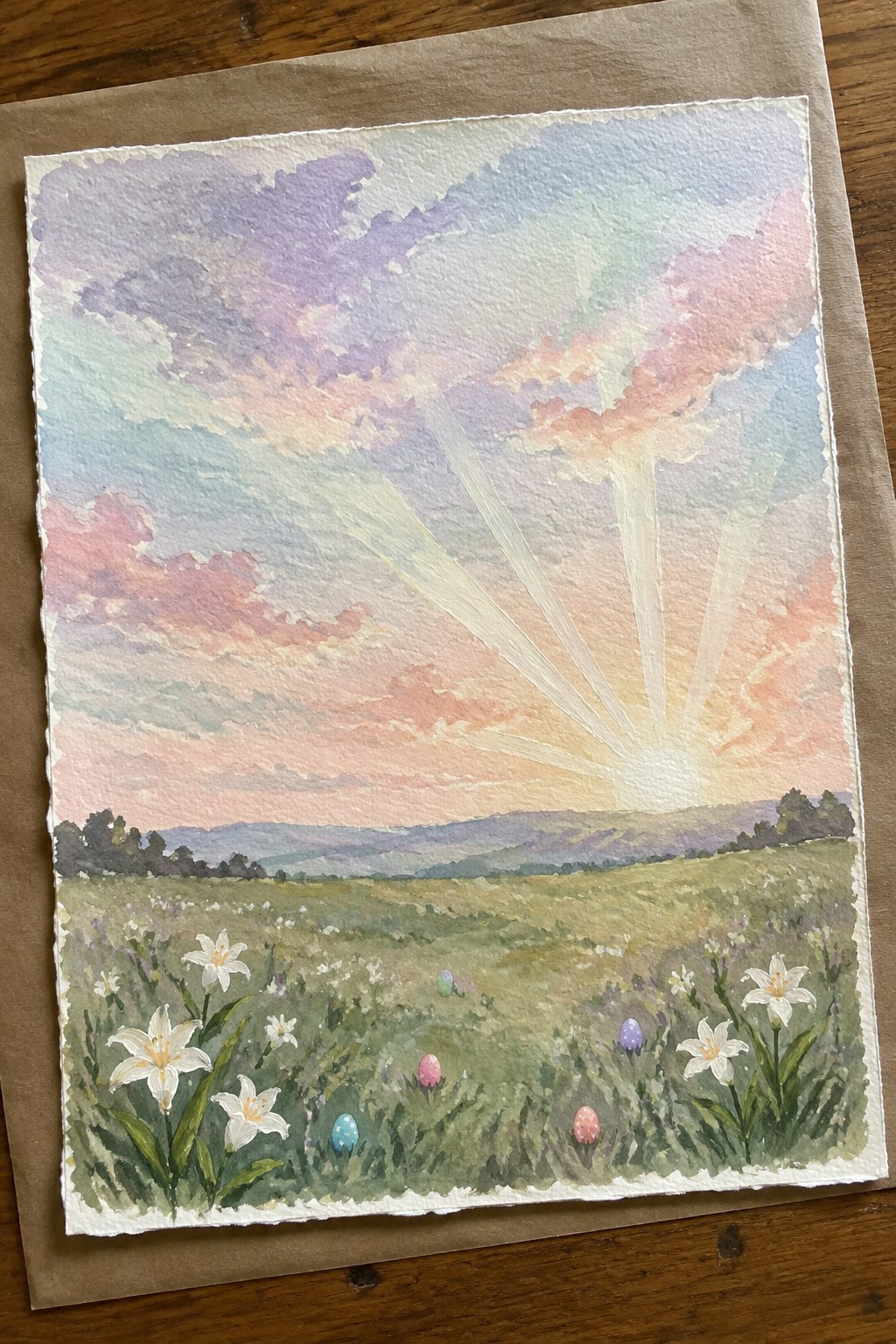 Watercolor painting of a sunrise over a meadow with white lilies and colorful Easter eggs scattered in the grass.