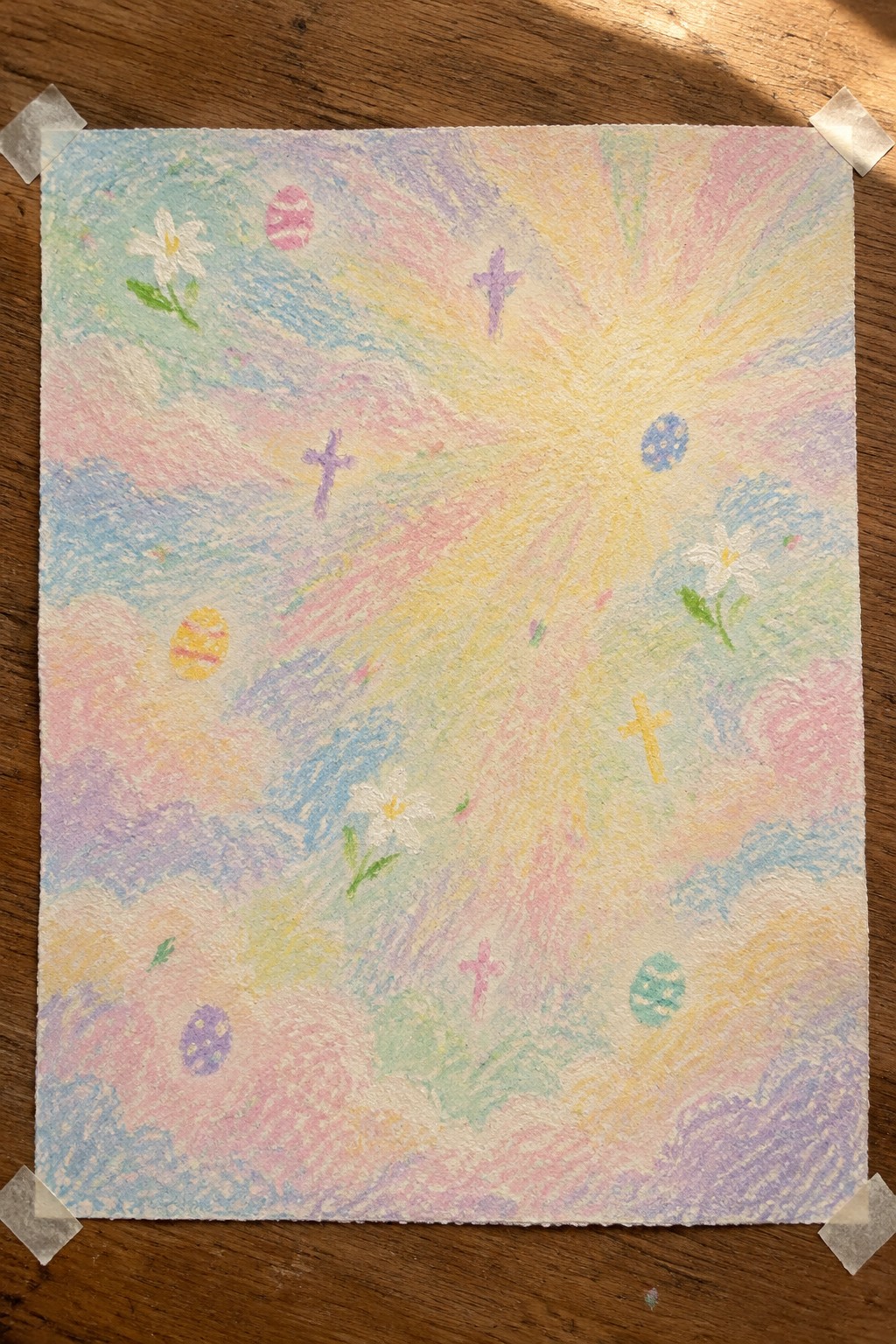 Pastel drawing of radiant sun, crosses, flowers, and Easter eggs taped on wood