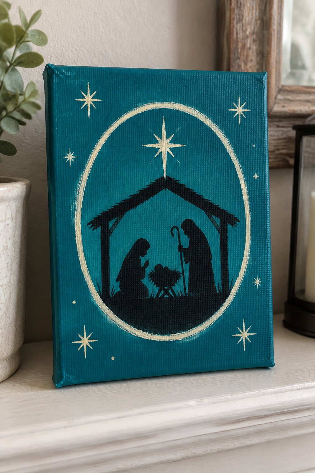 Teal canvas with black nativity silhouettes, stars, and beige circular border