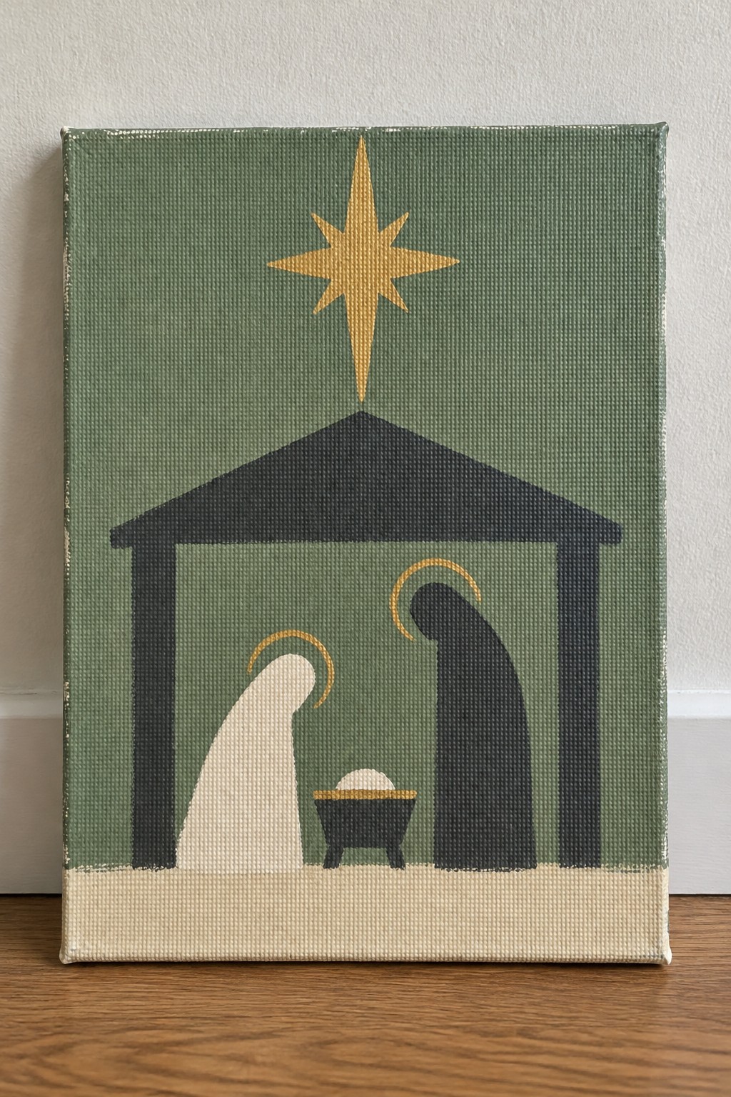 Minimalist green canvas nativity with golden star, black stable, and robed figures with halos