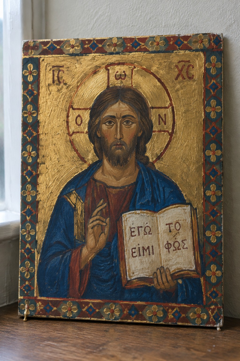 Byzantine icon of Jesus in blue-red robes with gold halo holding open Greek book
