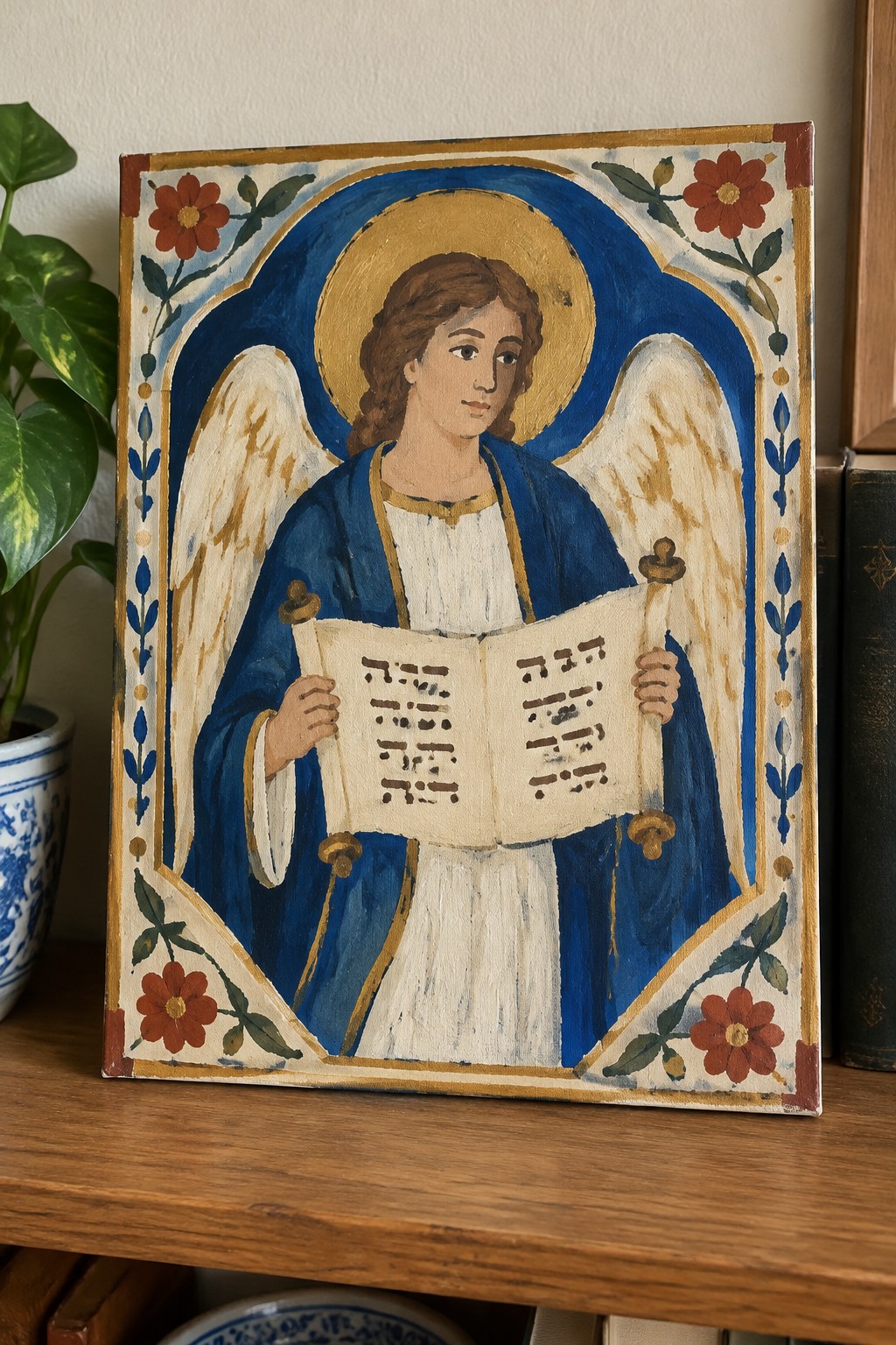 Angel with halo and wings in blue robe holds open music book, floral frame
