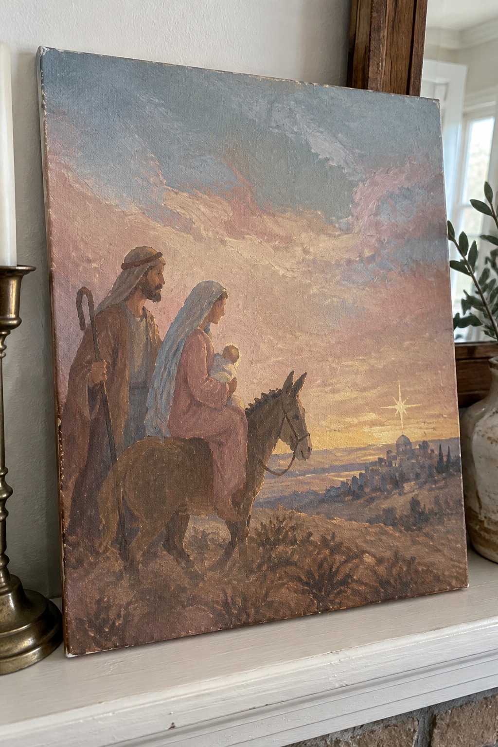 An oil painting of Joseph walking with a staff beside a donkey carrying Mary and baby Jesus, heading toward a town under a bright star at sunset.