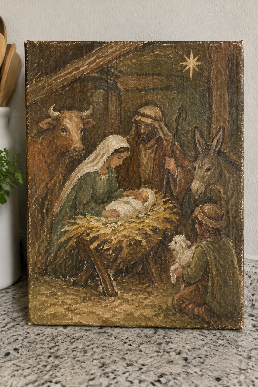 Earth-toned painting of Nativity with Mary in green veil, Joseph, manger, ox, donkey, shepherd