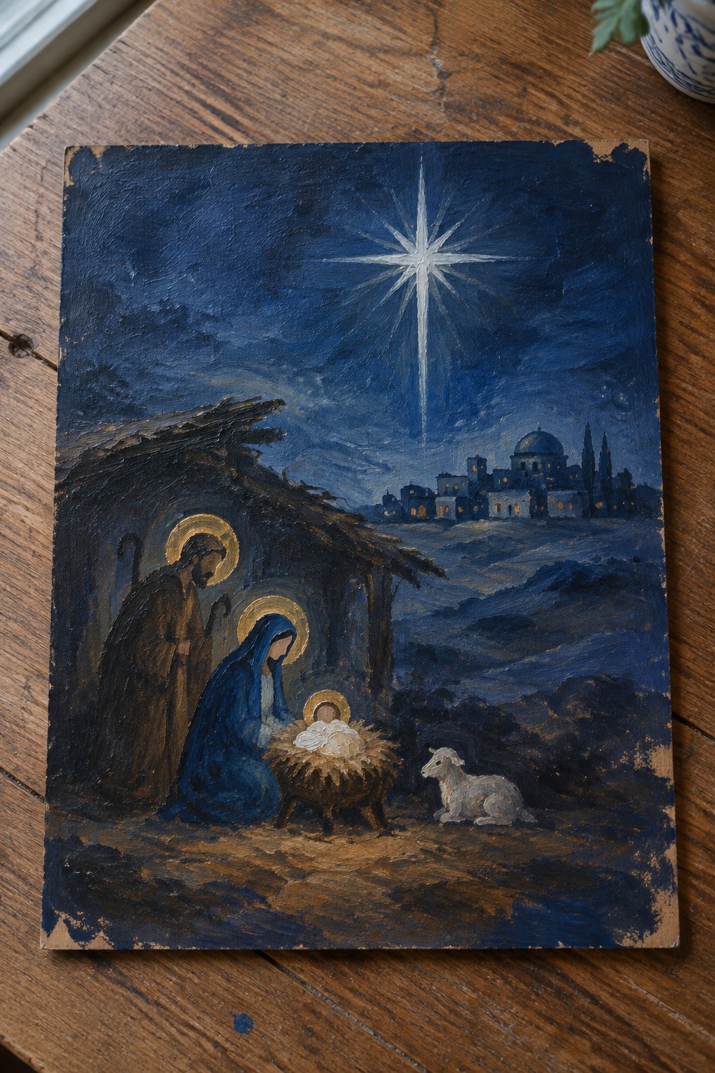 Nativity oil painting: Mary in blue robe, Joseph, baby in manger under radiant star with lamb.