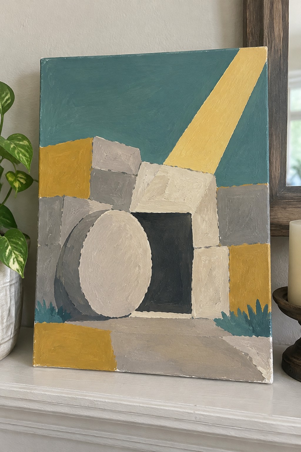 Abstract geometric painting with teal yellow gray blocks and diagonal stripe on mantel