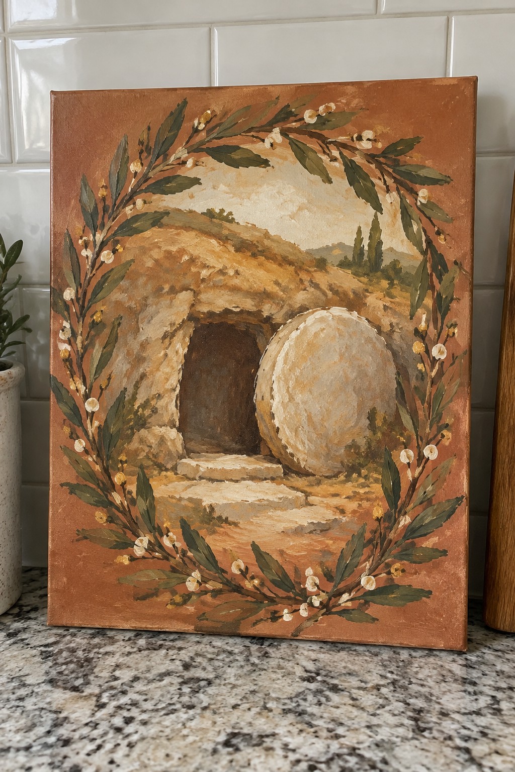 Empty tomb painting with rolled stone, framed by green leafy wreath with white flowers.