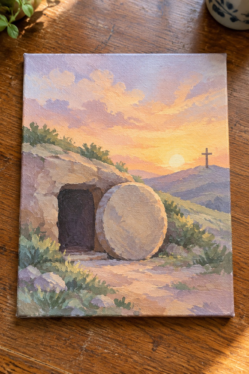 Sunrise painting of empty tomb with large stone rolled aside and hilltop cross