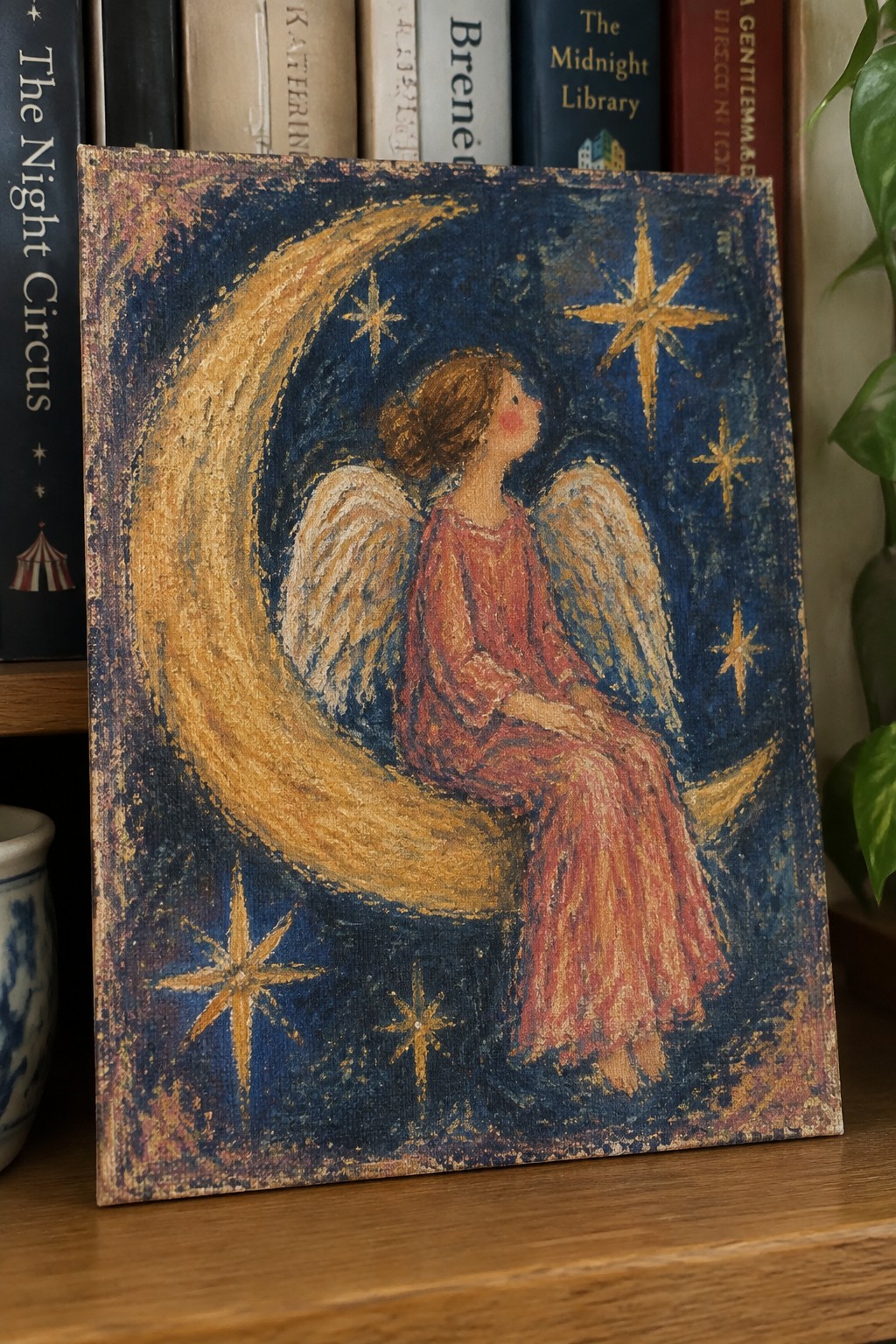 Winged woman in red dress sits on golden crescent moon amid starry blue sky.