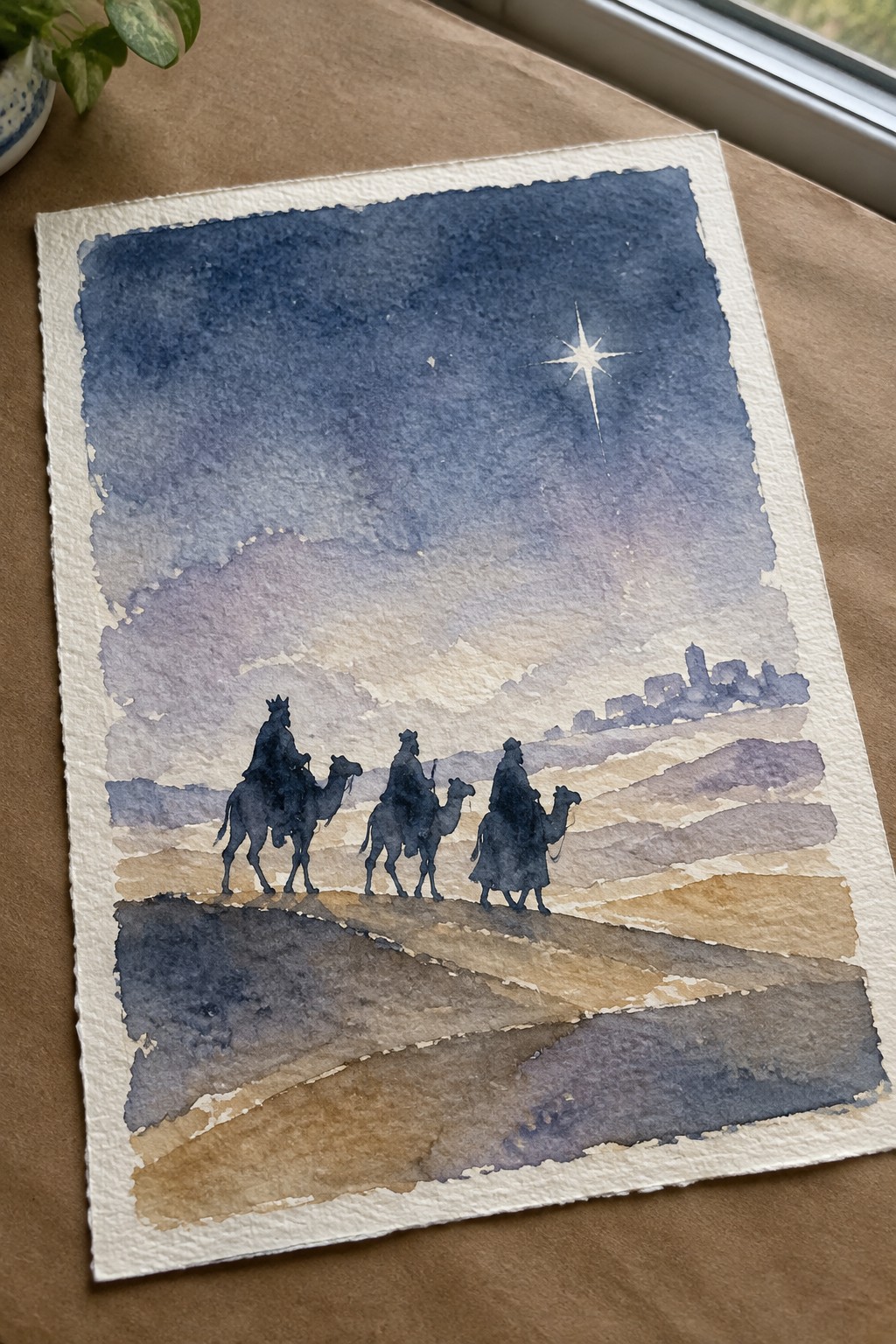 Watercolor of three camel riders approaching a distant town under a bright star.