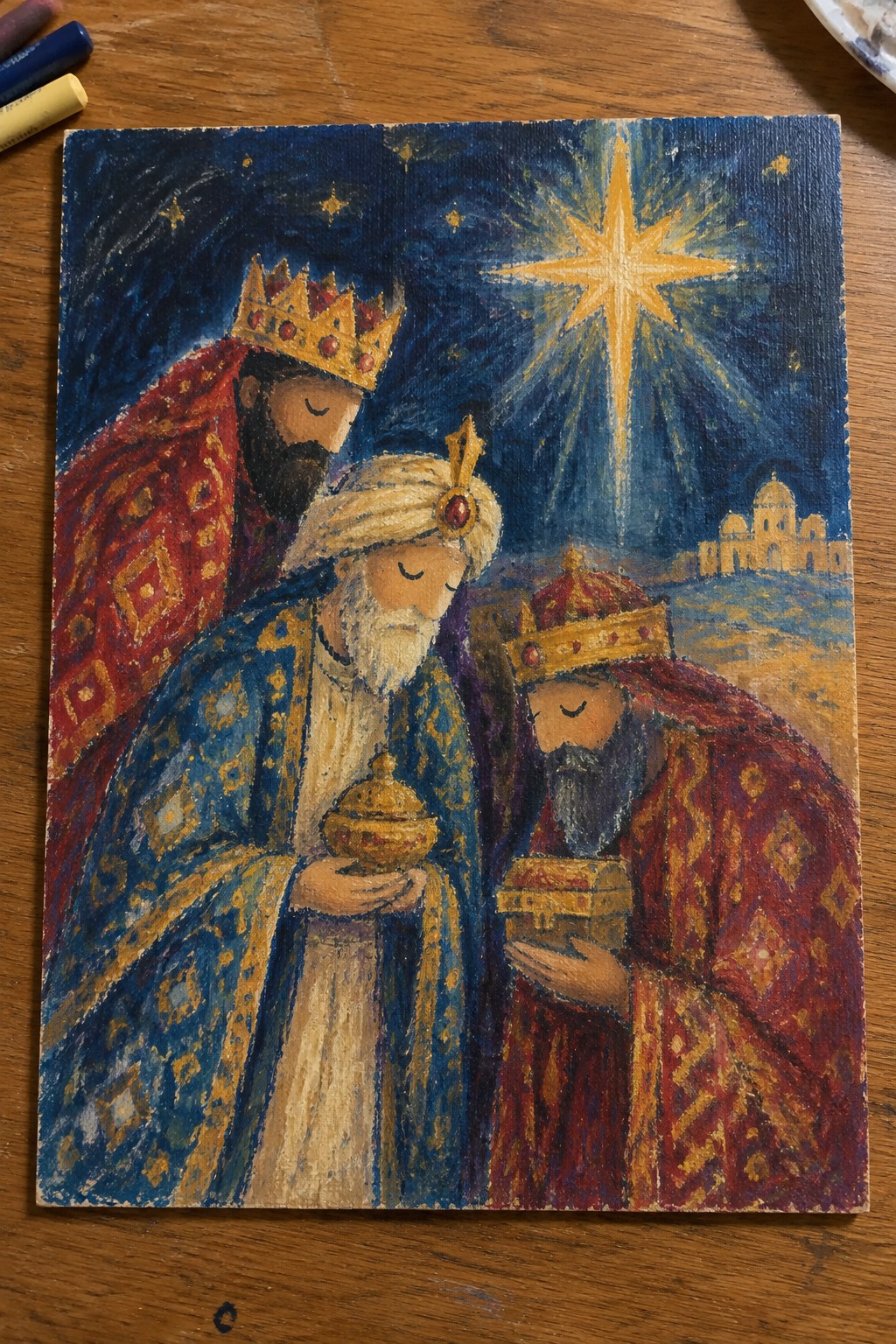Three kings in red and blue robes hold golden gifts under a radiant star.