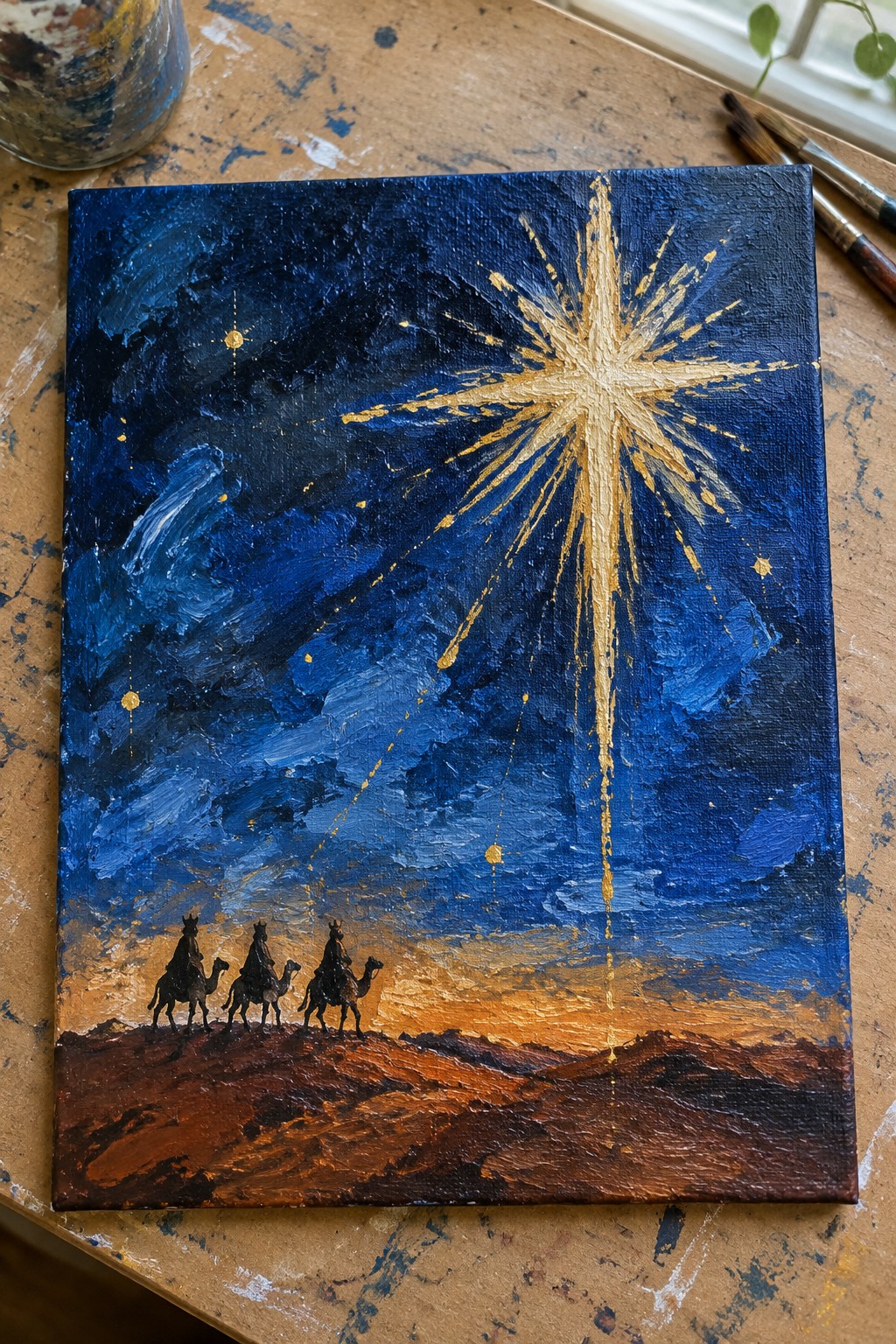 Three wise men on camels follow a radiant golden star in a dark blue sky.