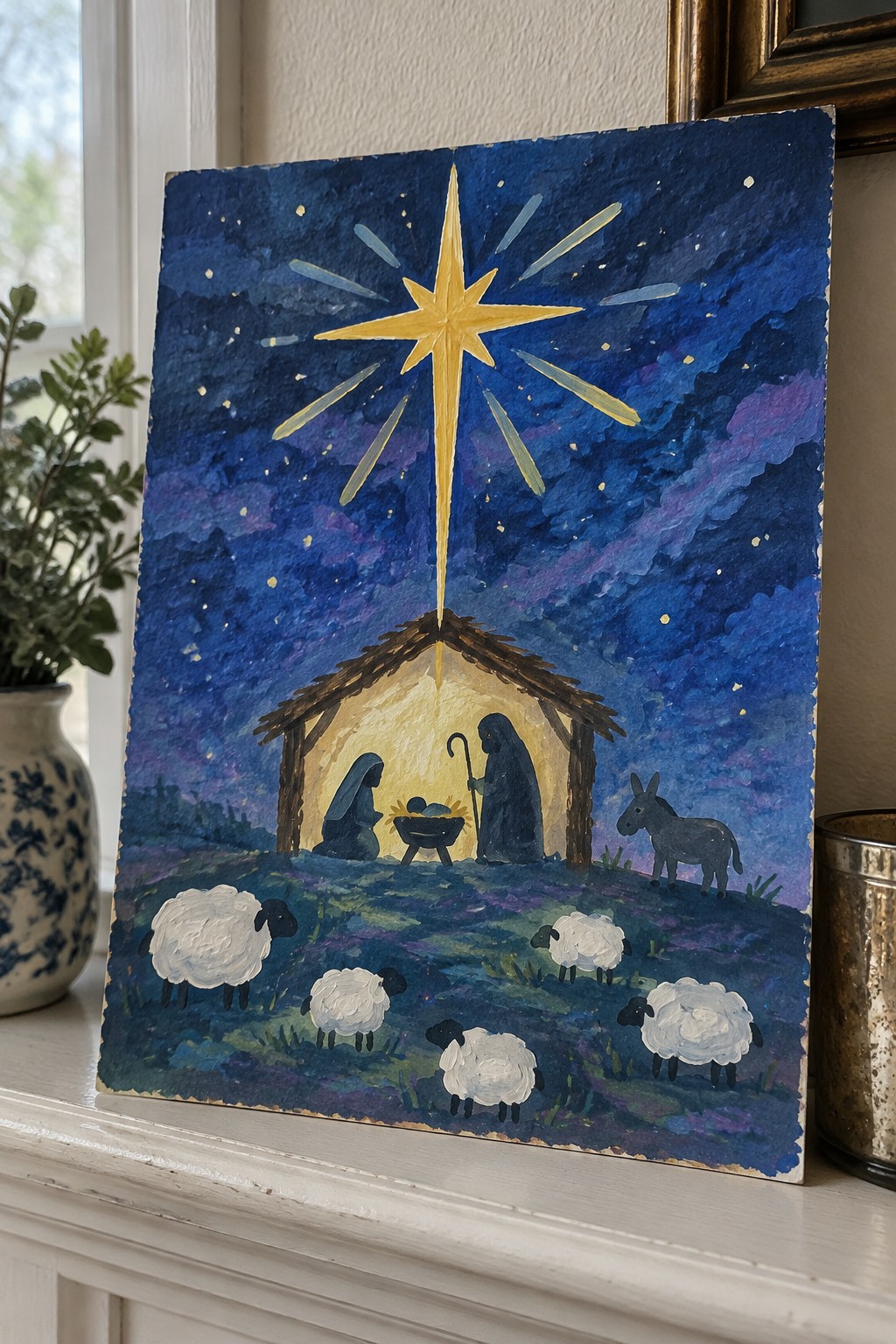 Nativity painting of large star over stable with Mary, Joseph, infant, donkey and sheep