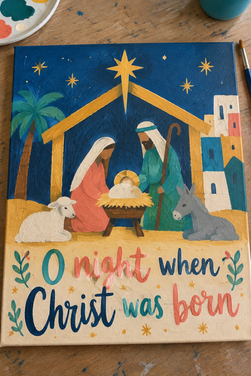 Vibrant folk-art nativity with Mary in red, Joseph in green, manger, sheep and donkey.