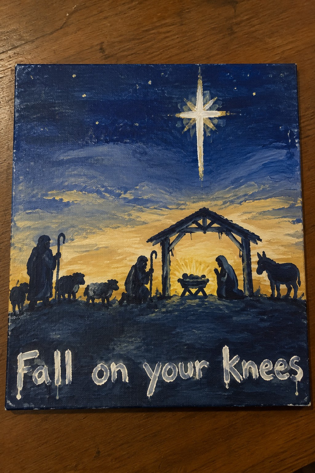 Silhouetted nativity painting with star, stable, figures, sheep, donkey and 