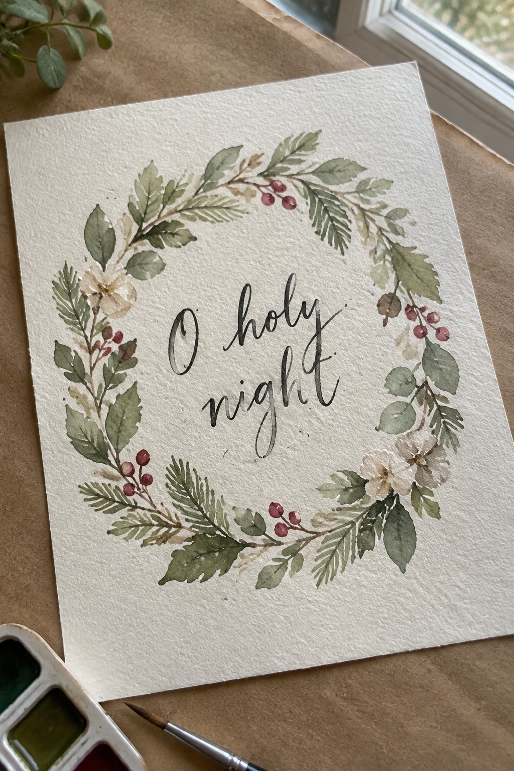 Watercolor wreath of green foliage, red berries, and white flowers around 