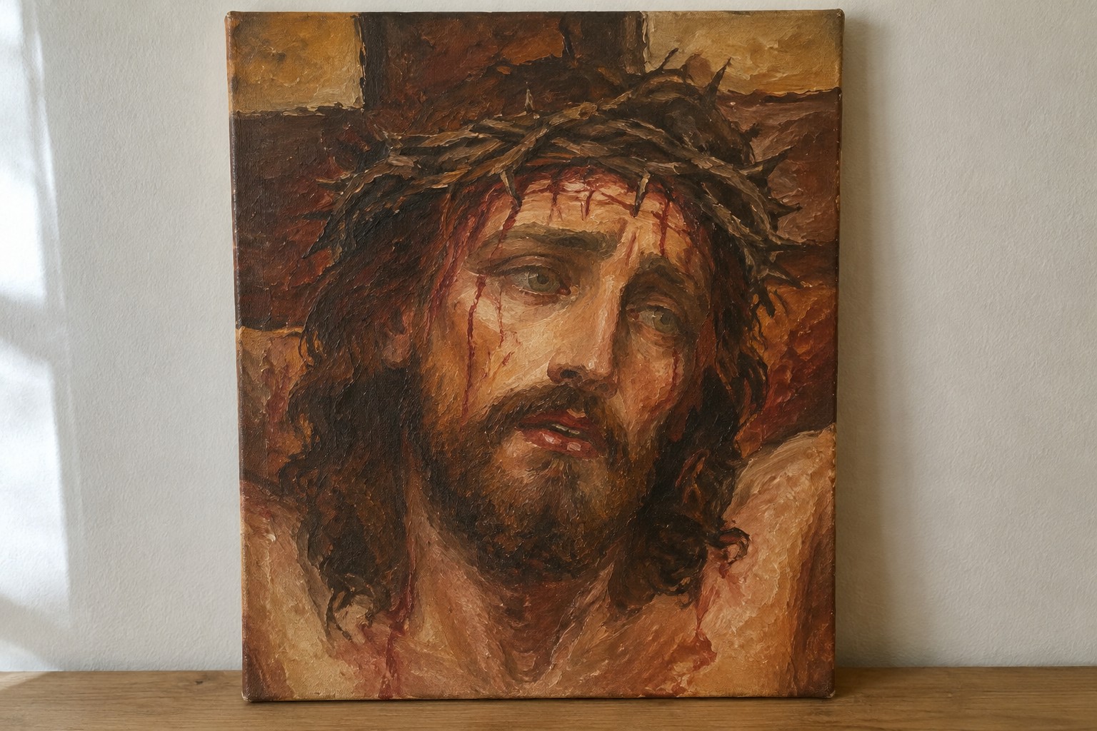 Close-up oil painting of Jesus with crown of thorns, blood streaking his face on cross.