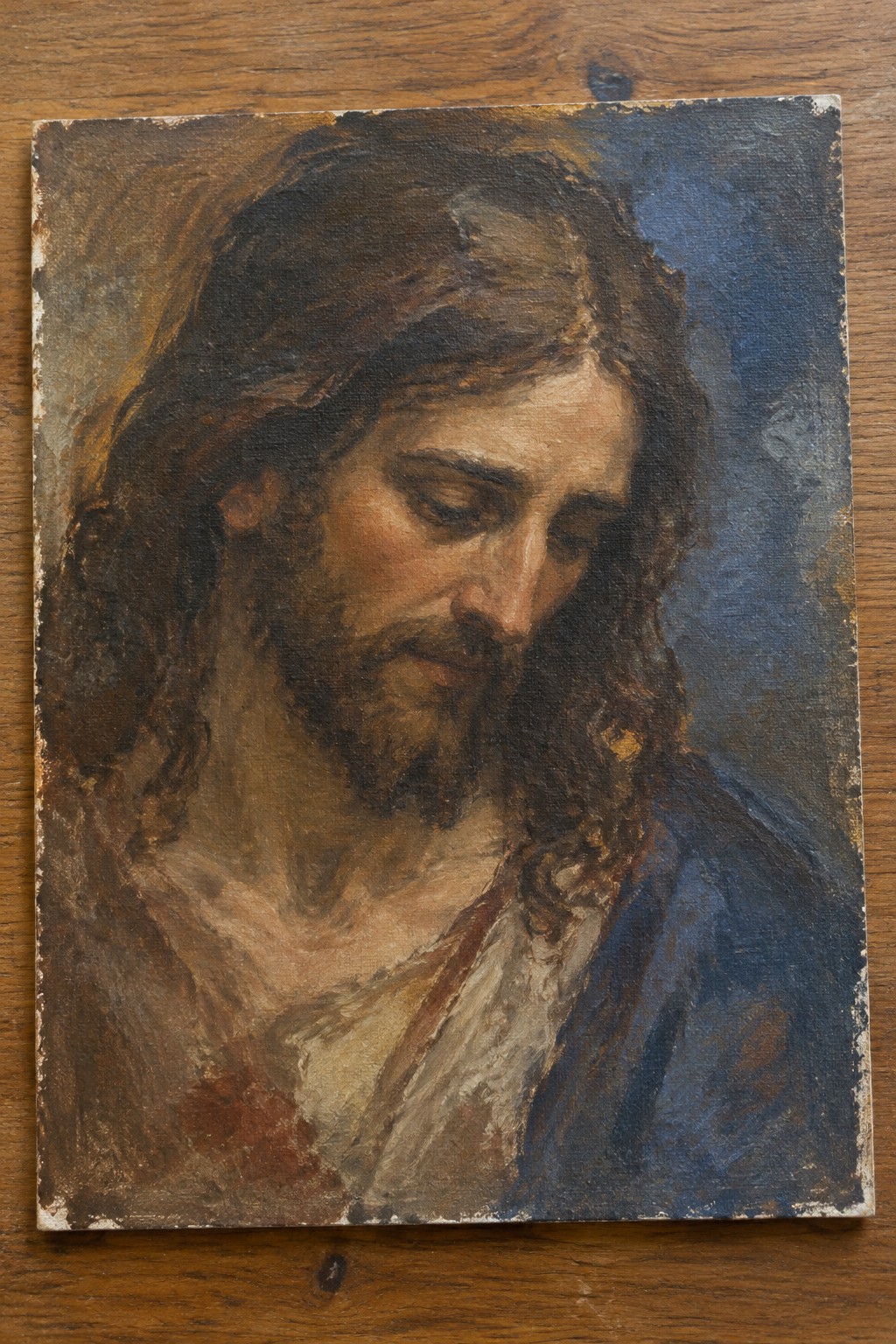 Oil painting of Jesus with long brown hair, beard, blue robe, head bowed.