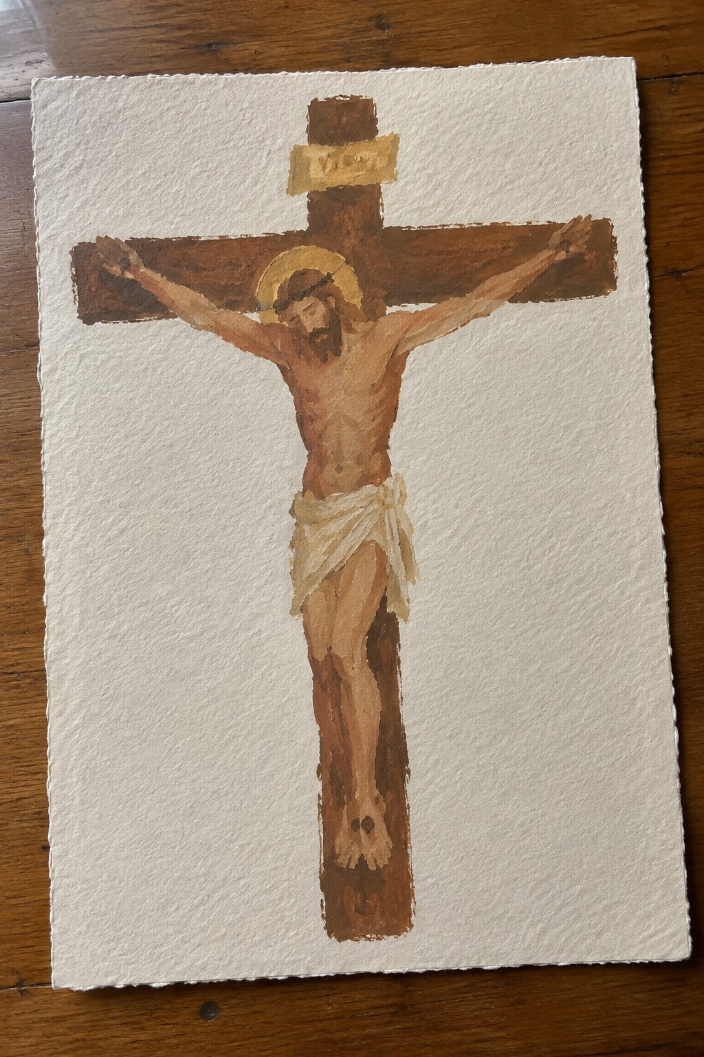 Watercolor of Jesus crucified on wooden cross with INRI sign, halo, and white loincloth