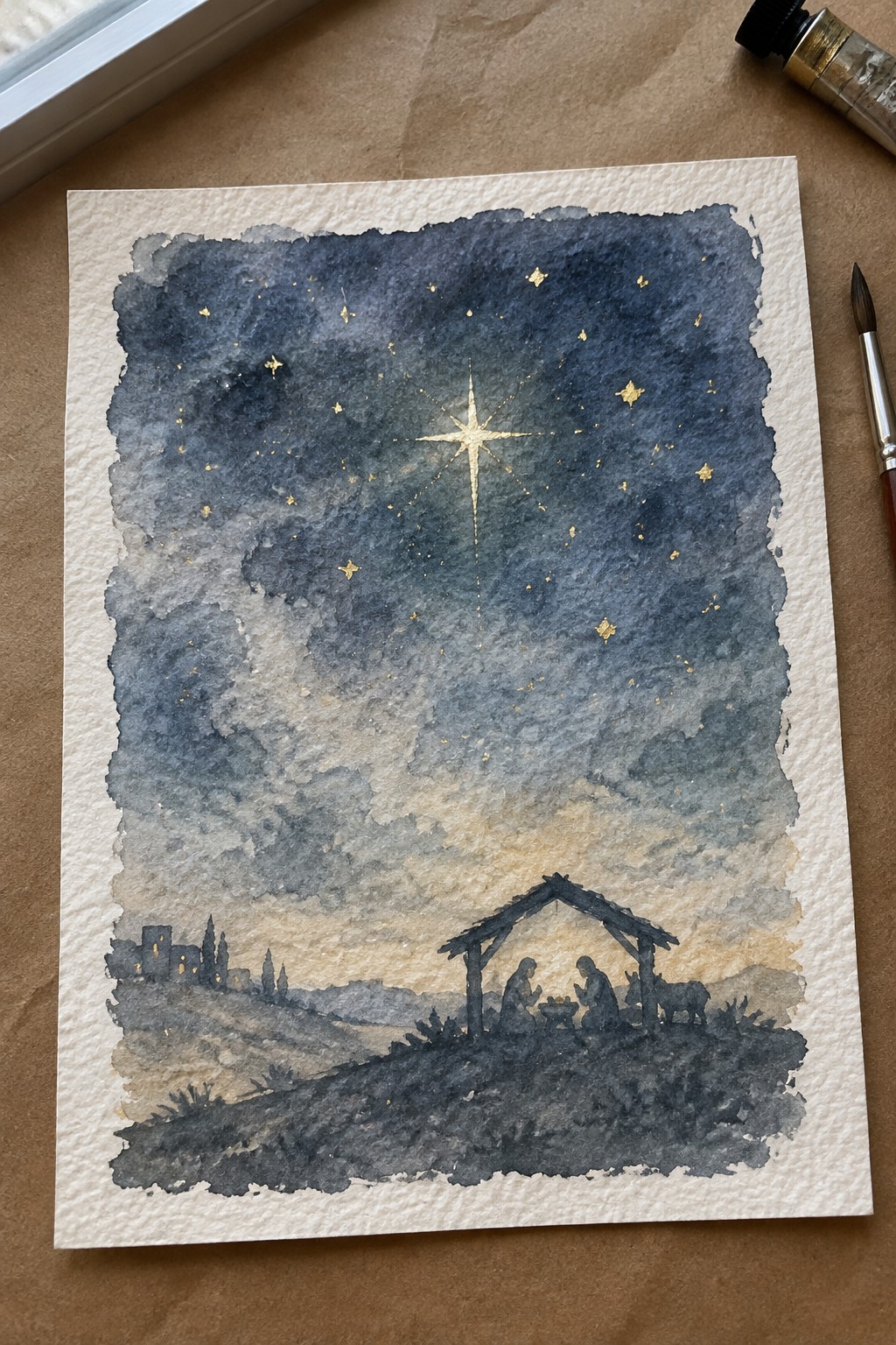 Watercolor nativity under golden star in dark blue cloudy night sky with hills