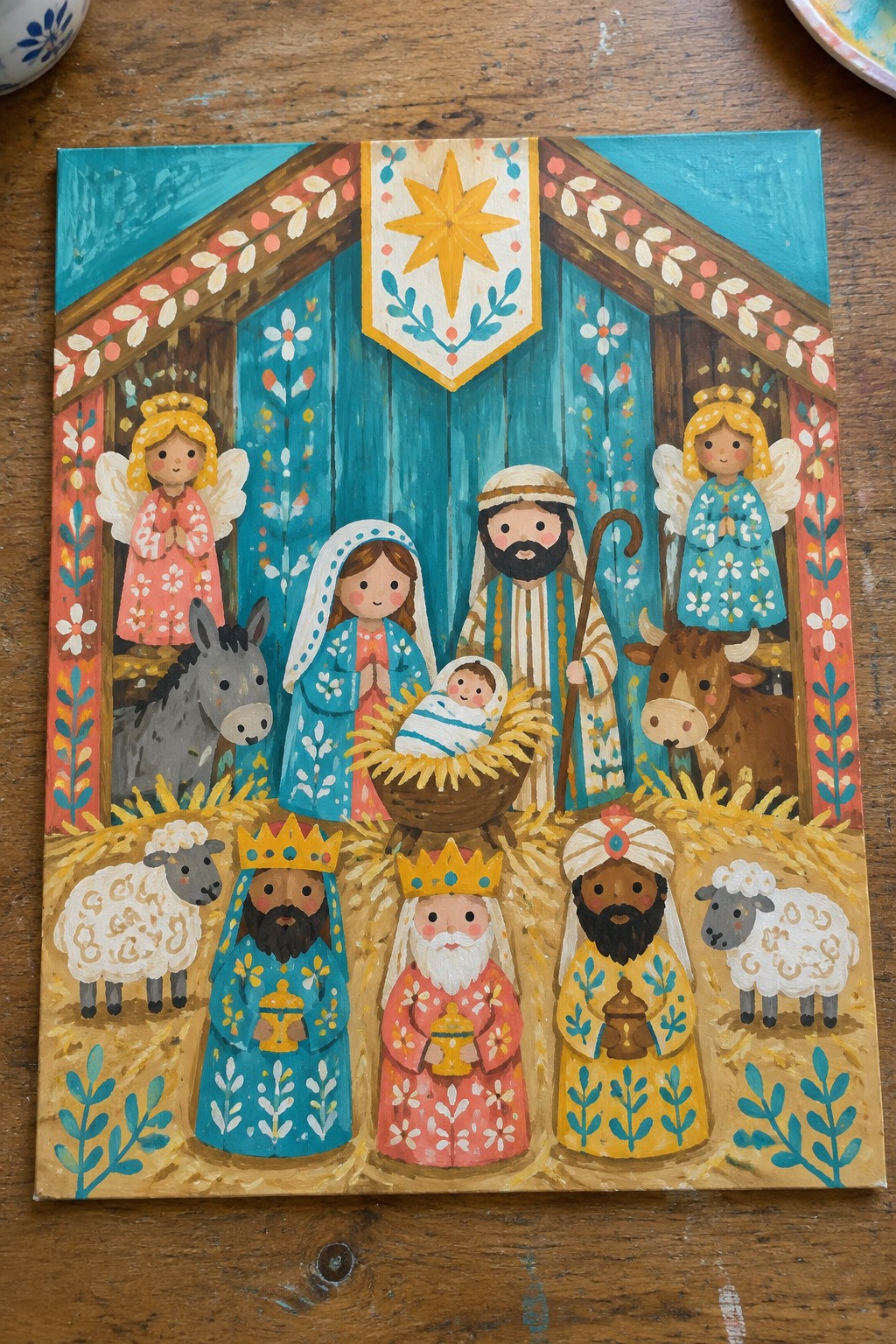 Folk art nativity painting with Mary, Joseph, baby Jesus, angels, kings, and animals in stable.