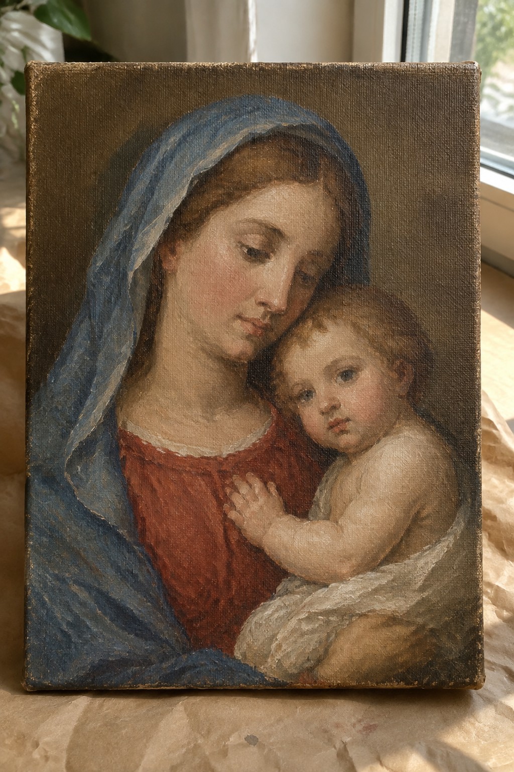 Classical painting of woman in blue veil and red dress holding infant against window
