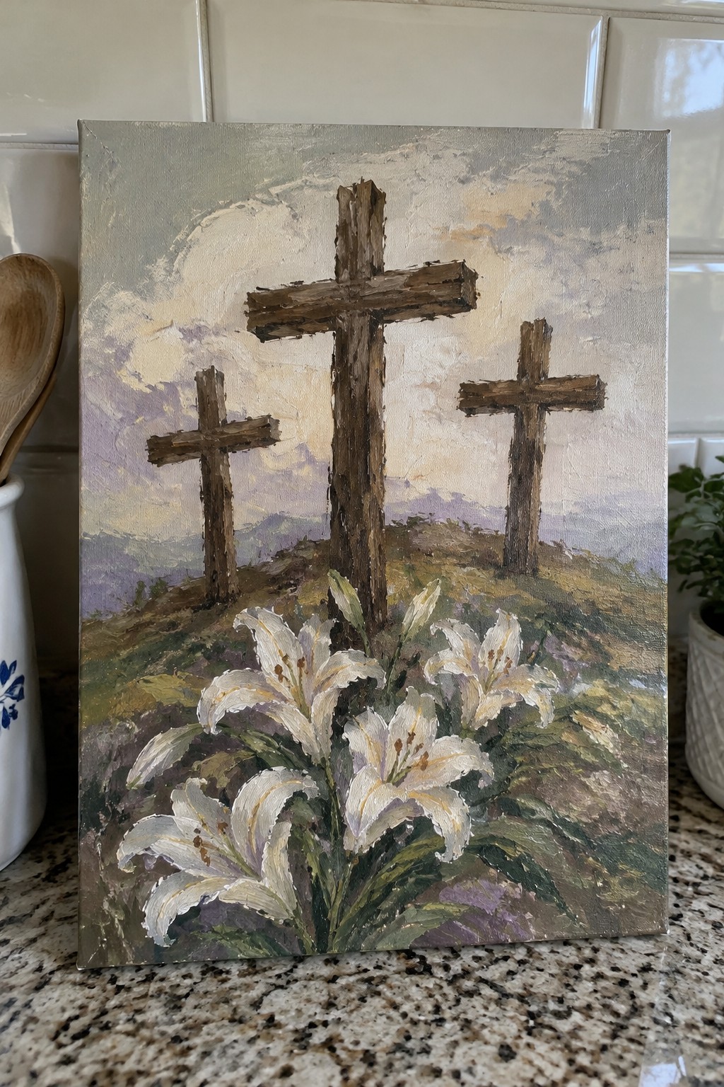 Three wooden crosses on a hill with white lilies in the foreground