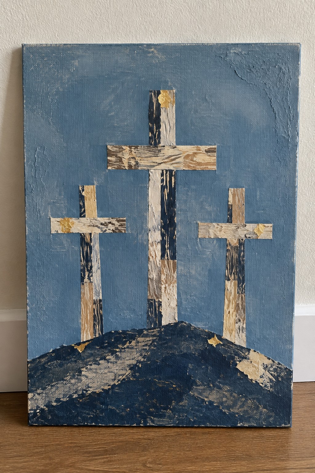 Three wooden crosses on a dark hill against textured blue background with gold accents