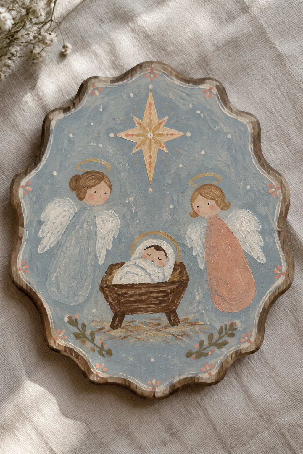Hand-painted wooden plaque with two angels, baby in manger, and golden star above