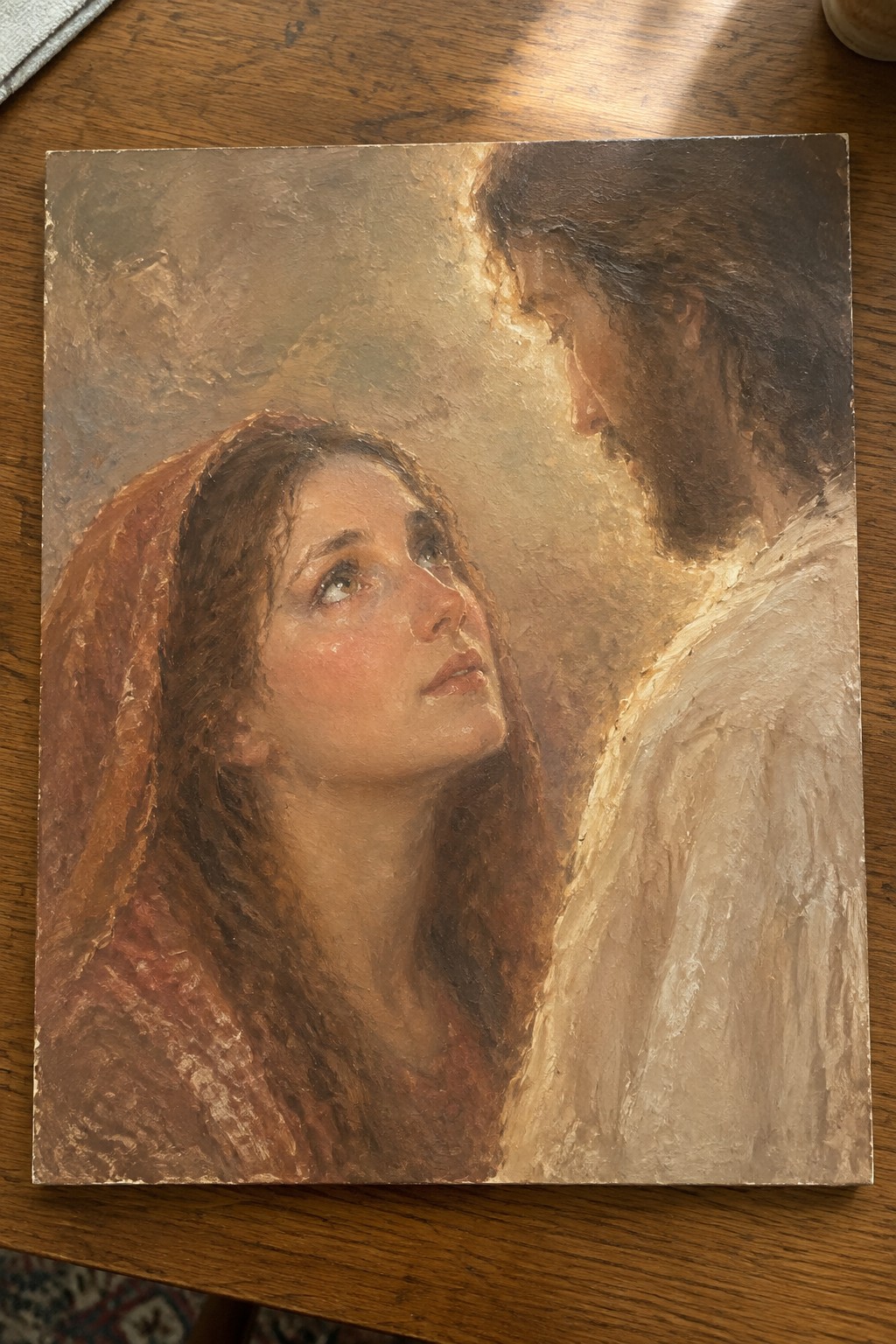 Painting of woman in red headscarf gazing up at bearded man in white robe.