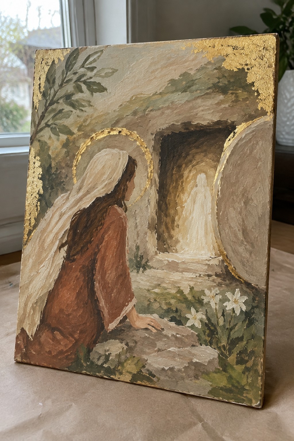 Veiled woman with golden halo in brown robe kneels before open tomb with glowing figure