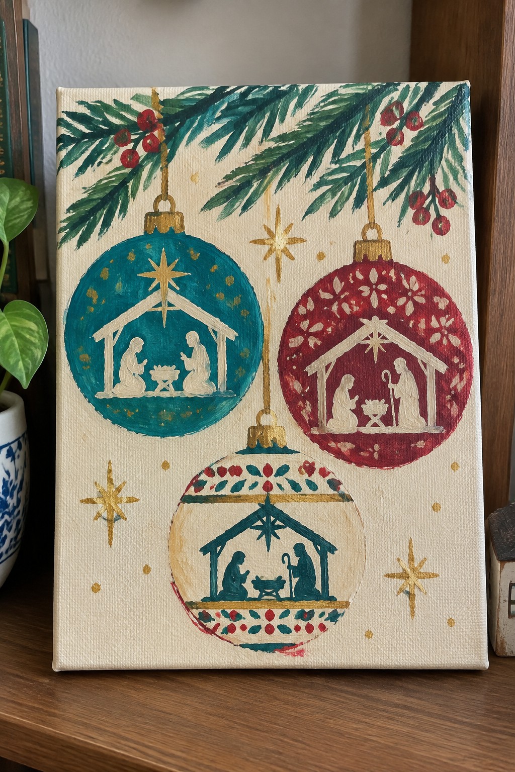 Three colorful Christmas ornaments with nativity scenes hang from pine branches amid gold stars.