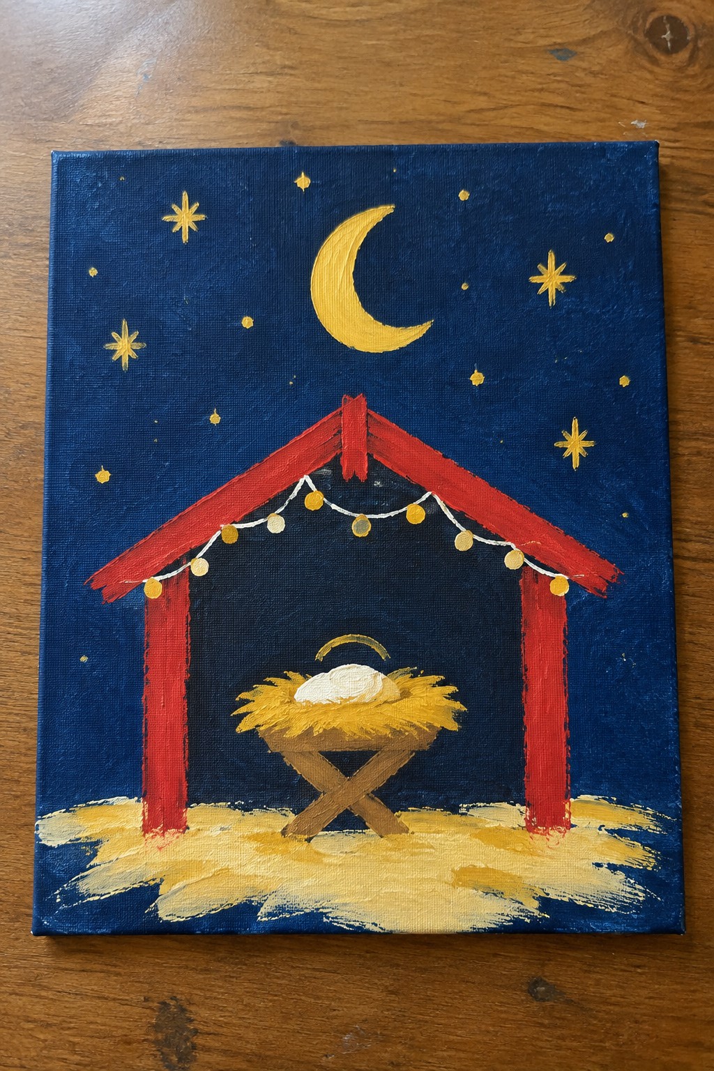 Acrylic painting of nativity manger in red stable under crescent moon and stars